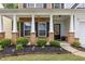 Inviting front porch with brick and white pillars, complemented by manicured landscaping and charming details at 4266 Suwanee Brook Ct, Buford, GA 30518