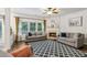 Cozy living room with fireplace, ceiling fan, and large windows offering lots of natural light at 4266 Suwanee Brook Ct, Buford, GA 30518