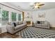 Cozy living room with fireplace, ceiling fan, and large windows offering lots of natural light at 4266 Suwanee Brook Ct, Buford, GA 30518