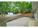 Spacious backyard with mature trees, gravel parking area, storage shed, and wooden perimeter fence at 2045 Sherwood Se Dr, Marietta, GA 30067