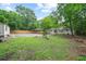 Spacious backyard with green grass, trees, fenced perimeter, and a storage shed at 2045 Sherwood Se Dr, Marietta, GA 30067