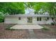 Rear view of the home features a concrete patio and a backyard surrounded by lush trees and greenery at 2045 Sherwood Se Dr, Marietta, GA 30067