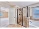 Elegant bathroom featuring a tiled shower with a glass door, soaking tub and neutral color palette at 3642 Lake Estates Way Way, Atlanta, GA 30349