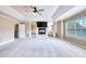 Bright bedroom with a cozy fireplace, television, tray ceiling, and adjacent sitting area beyond decorative columns at 3642 Lake Estates Way Way, Atlanta, GA 30349