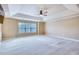 Expansive bedroom with a tray ceiling, ceiling fan, and large window overlooking the landscaped yard at 3642 Lake Estates Way Way, Atlanta, GA 30349