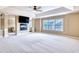 Spacious bedroom with a fireplace, mounted television, tray ceiling with fan, and a large window at 3642 Lake Estates Way Way, Atlanta, GA 30349
