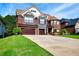 Beautiful two-story brick and stone home with a lush green lawn and three-car garage at 3642 Lake Estates Way Way, Atlanta, GA 30349