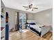Neutral bedroom with laminate floors, ceiling fan, and large window at 3897 Tanbark Ct, Marietta, GA 30066