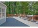 An expansive wooden deck featuring an outdoor grill and a view of the surrounding lush greenery at 3897 Tanbark Ct, Marietta, GA 30066