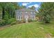 Charming two-story brick home featuring a well-manicured lawn, mature trees, and colorful flower beds at 3897 Tanbark Ct, Marietta, GA 30066