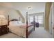 Bright bedroom featuring a four-poster bed, bedside table, and built-in desk near the windows at 414 Wallis Farm Way, Marietta, GA 30064
