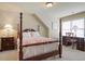 Bedroom featuring a four-poster bed, bedside table, and built-in desk near the windows at 414 Wallis Farm Way, Marietta, GA 30064