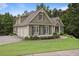 Side view of an elegant home with a three-car garage, beautiful landscaping, and a well-kept lawn at 414 Wallis Farm Way, Marietta, GA 30064