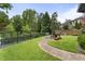 Landscaped backyard with a brick pathway leading to an outdoor seating area, fountain and well manicured grass at 570 Society St, Alpharetta, GA 30022