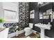 Stylish bathroom features a pedestal sink, decorative wallpaper, updated fixtures, and natural light at 570 Society St, Alpharetta, GA 30022