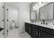 Stylish bathroom with dual sinks, black hardware, and modern mirrors offers a luxurious space at 570 Society St, Alpharetta, GA 30022