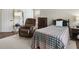 Comfortable bedroom with a recliner, wood dresser, soft carpet and natural light at 570 Society St, Alpharetta, GA 30022