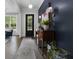 Elegant entryway with a dark blue accent wall, hardwood floors, and stylish decor at 570 Society St, Alpharetta, GA 30022