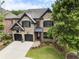 Beautiful brick home with a two-car garage, well-kept lawn, and professionally landscaped yard at 570 Society St, Alpharetta, GA 30022