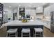 Modern kitchen with a large island, white cabinetry, stainless steel appliances, and stylish bar stools at 570 Society St, Alpharetta, GA 30022