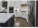 Kitchen boasts white cabinets, stainless steel appliances, and hardwood floors, perfect for culinary enthusiasts at 570 Society St, Alpharetta, GA 30022