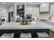 A kitchen features a large island with seating, white cabinets, open shelving, and modern stainless steel appliances at 570 Society St, Alpharetta, GA 30022