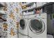 Modern laundry room features side-by-side washer and dryer and shelving for storage at 570 Society St, Alpharetta, GA 30022