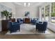 Bright living room with hardwood floors, stylish blue chairs, and a large window at 570 Society St, Alpharetta, GA 30022