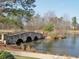 Scenic community pond featuring a charming stone bridge and lush natural surroundings at 570 Society St, Alpharetta, GA 30022