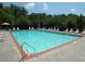Community pool with lounge chairs and a view of surrounding greenery at 570 Society St, Alpharetta, GA 30022