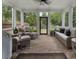 Cozy screened porch with wicker furniture, offering a relaxing outdoor living space at 570 Society St, Alpharetta, GA 30022