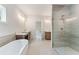 Modern bathroom featuring dual vanities, a soaking tub, and a glass-enclosed shower with elegant fixtures at 675 Crest Line Trl, Powder Springs, GA 30127