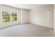 Empty bedroom with neutral carpet, a large window, and a view of mature trees at 675 Crest Line Trl, Powder Springs, GA 30127