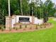 Stone and brick sign at Ashbury Commons welcomes residents with lush landscaping and manicured lawns at 675 Crest Line Trl, Powder Springs, GA 30127