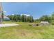Sprawling backyard features mature trees, lush lawn, and a distant barn, offering privacy and space for outdoor activities at 3040 Sandy Creek Ct, Loganville, GA 30052