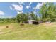 Metal outbuilding or barn surrounded by a large grassy lawn, a perfect location for storage or hobbies at 3040 Sandy Creek Ct, Loganville, GA 30052