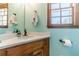 Charming bathroom with a wood vanity, light countertops, and wood-trimmed windows offers a serene retreat at 3040 Sandy Creek Ct, Loganville, GA 30052
