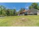 Well-maintained home with a vast, sloping lawn, mature trees, and a white fence enhancing its picturesque setting at 3040 Sandy Creek Ct, Loganville, GA 30052