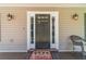 Close-up showcasing the entryway, featuring a dark wood door, stylish lamps, and a welcoming mat at 3040 Sandy Creek Ct, Loganville, GA 30052