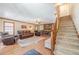 Spacious living room features hardwood floors, a brick fireplace, and a staircase at 3040 Sandy Creek Ct, Loganville, GA 30052