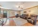 Cozy living room with hardwood floors, a brick fireplace, complemented by natural light from the windows at 3040 Sandy Creek Ct, Loganville, GA 30052