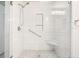 Modern tiled shower with glass door, built-in niche, and convenient bench at 3310 Bryan Way, Marietta, GA 30008