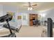 Home gym area with carpet flooring, work station, door to outside, ceiling fan, and treadmill at 4119 Alayna Lee Cir, Mcdonough, GA 30252