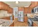 Updated kitchen featuring wood cabinets, stainless steel appliances, granite countertops, and a tile backsplash at 4119 Alayna Lee Cir, Mcdonough, GA 30252