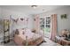 Comfortable bedroom with soft pink decor, window, and carpeted floors offers coziness at 6597 River Island Drive Dr, Buford, GA 30518