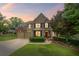 Charming two-story home boasts a manicured lawn, brick accents, and inviting front porch at 6597 River Island Drive Dr, Buford, GA 30518