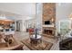 Open-concept living room boasts stone fireplace and flows seamlessly to kitchen with island seating at 6597 River Island Drive Dr, Buford, GA 30518