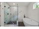 A modern bathroom with a soaking tub, a separate glass shower, and dark fixtures at 1564 Belva Ave, Decatur, GA 30032
