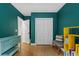 Cozy bedroom features teal walls, light hardwood floors, and a closet at 1564 Belva Ave, Decatur, GA 30032
