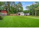 Beautiful home exterior featuring a lush green lawn and mature trees in a serene, fenced in backyard setting at 1564 Belva Ave, Decatur, GA 30032